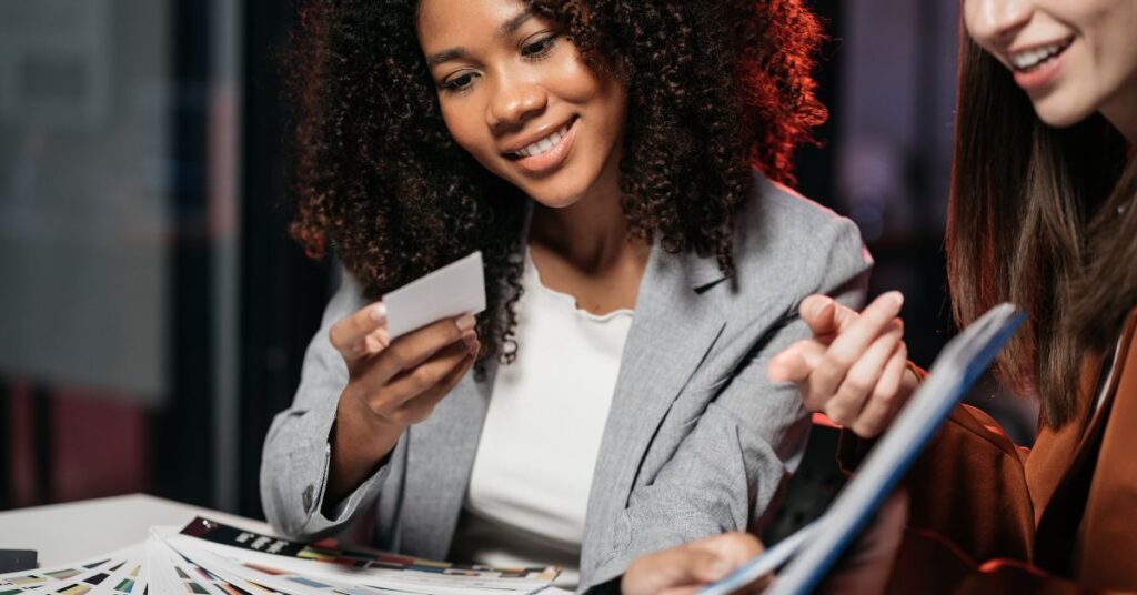 Two girls looking at business cards.